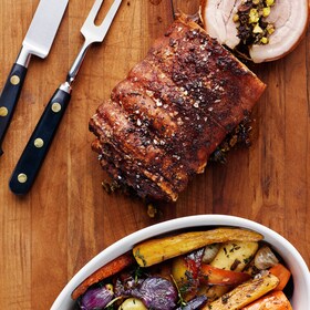 A roll of golden roasted pork and crispy roasted winter vegetables