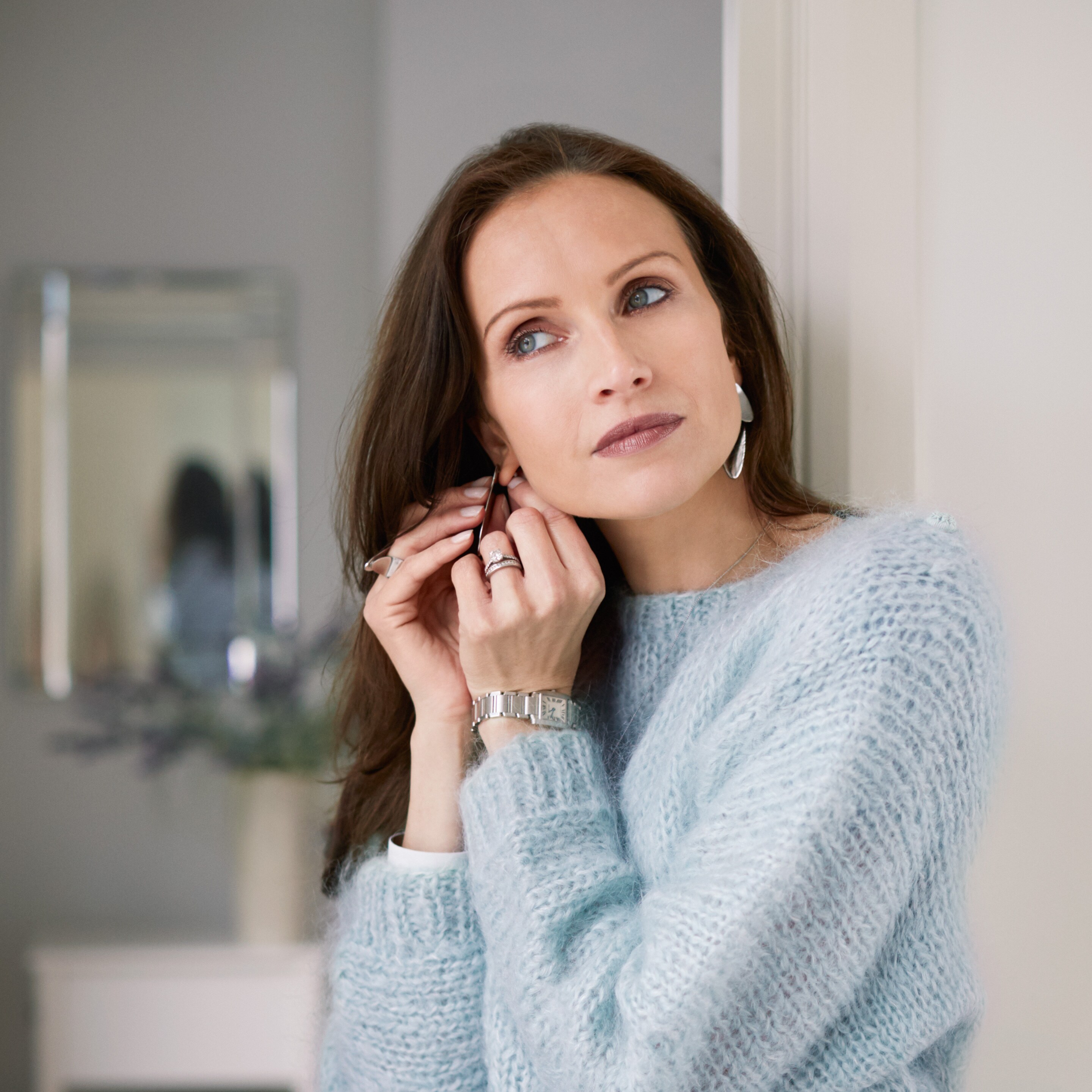 A women admiring her blue woollen jumper